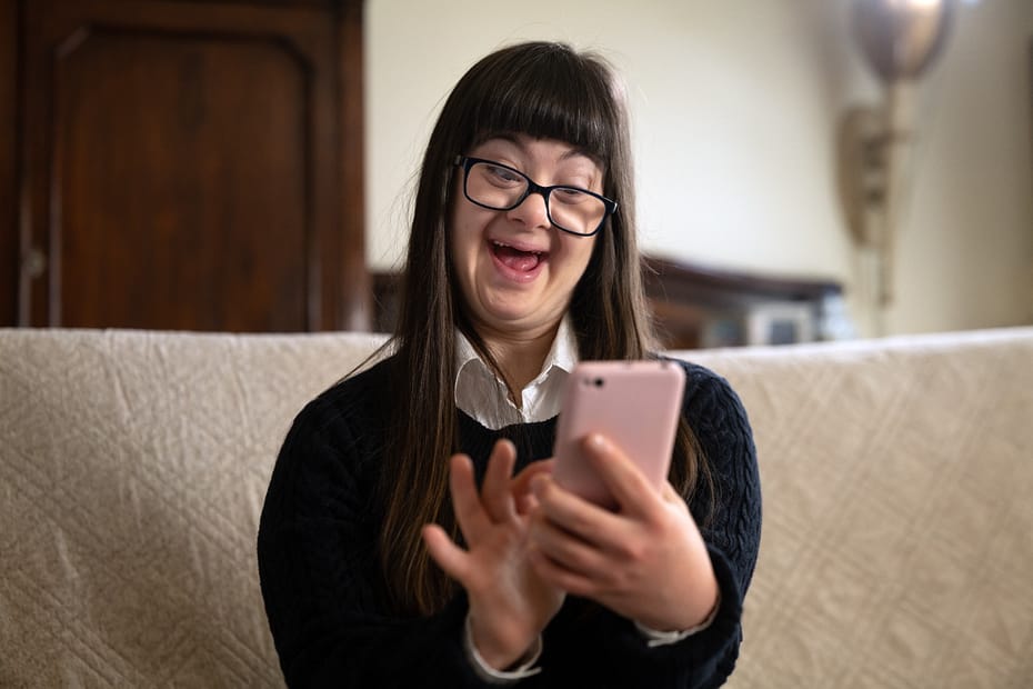 A young woman taking a selfie on her phone on the couch